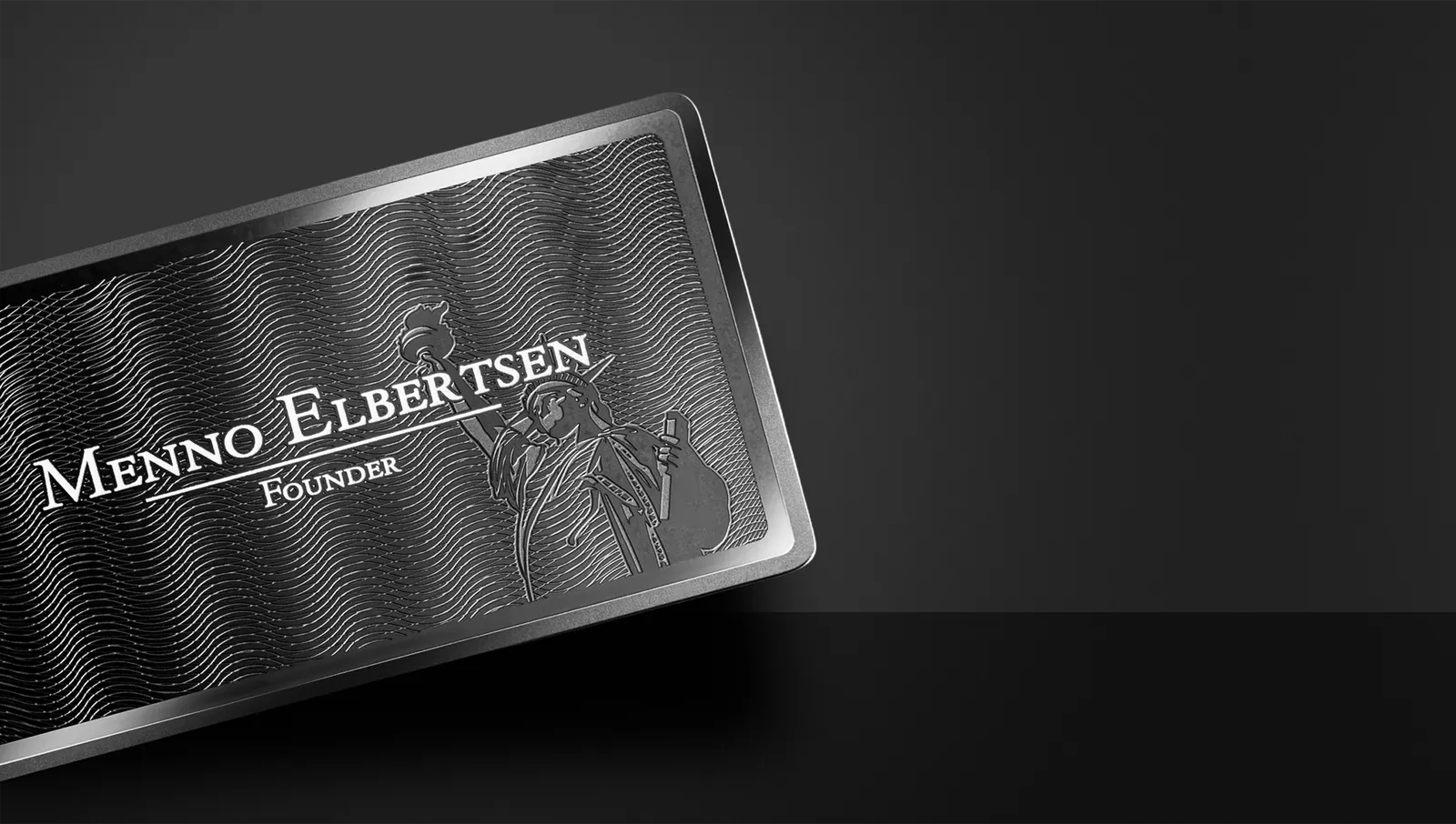 Cardique black metal business card on a charcoal surface