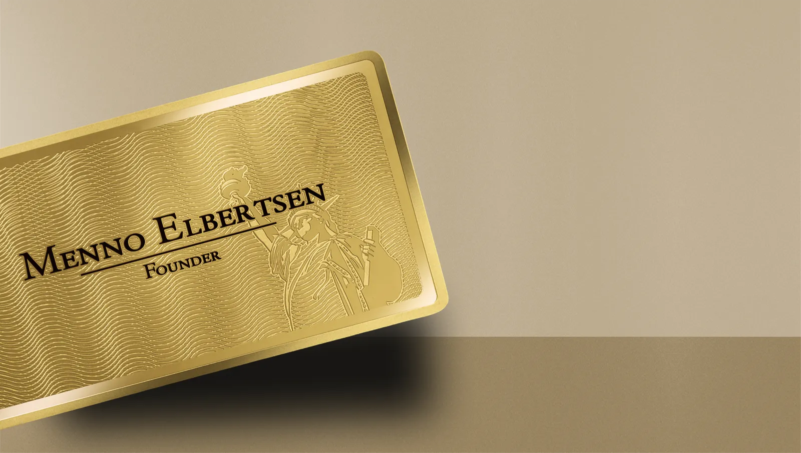 Cardique gold metal business card on a warm champagne surface